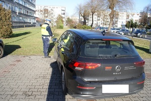 VW Golf samochód biorący udział w zdarzeniu w tle policjant ruchu drogowego.