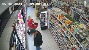kobieta idzie w kierunku mężczyzny,który ogląda artykuły drogeryjne w sklepie.