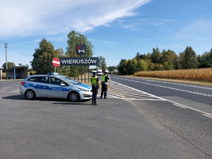 policjanci ruchu drogowego mierzą prędkość nadjeżdżającego pojazdu.