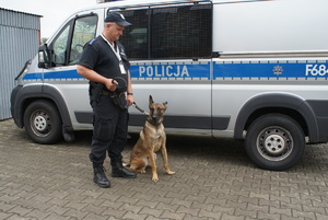policjant z psem przy radiowozie typu bus.