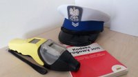 Policyjna czapka, kodeks karny i urządzenie do badania stanu trzeźwości w wydychanym powietrzu